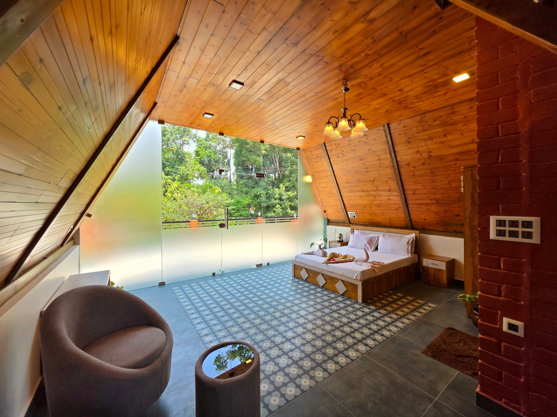 A-frame cottage attic with king bed and floor-to-ceiling glass window