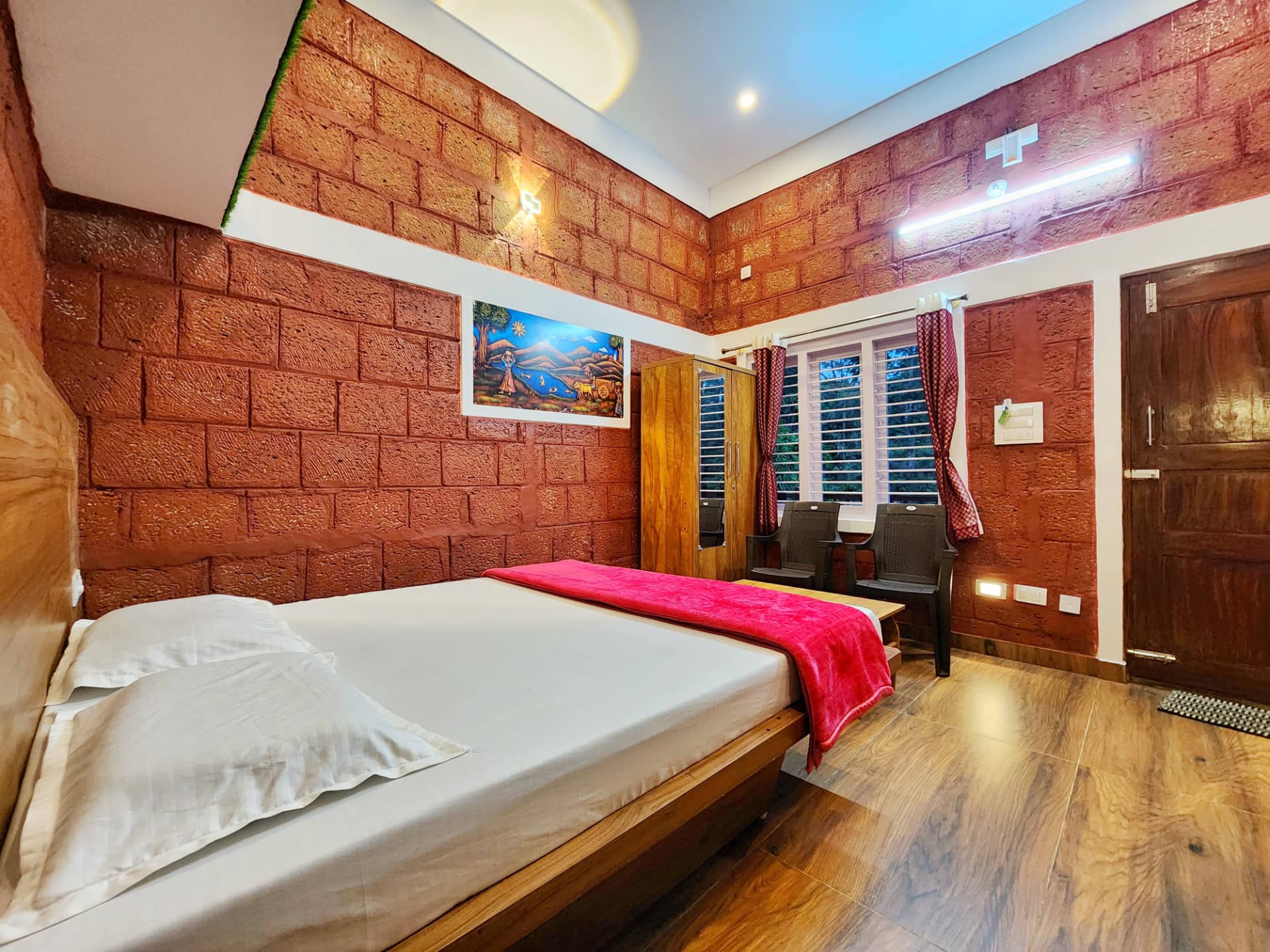 Stone Age Room double bed with rustic laterite walls and warm lighting