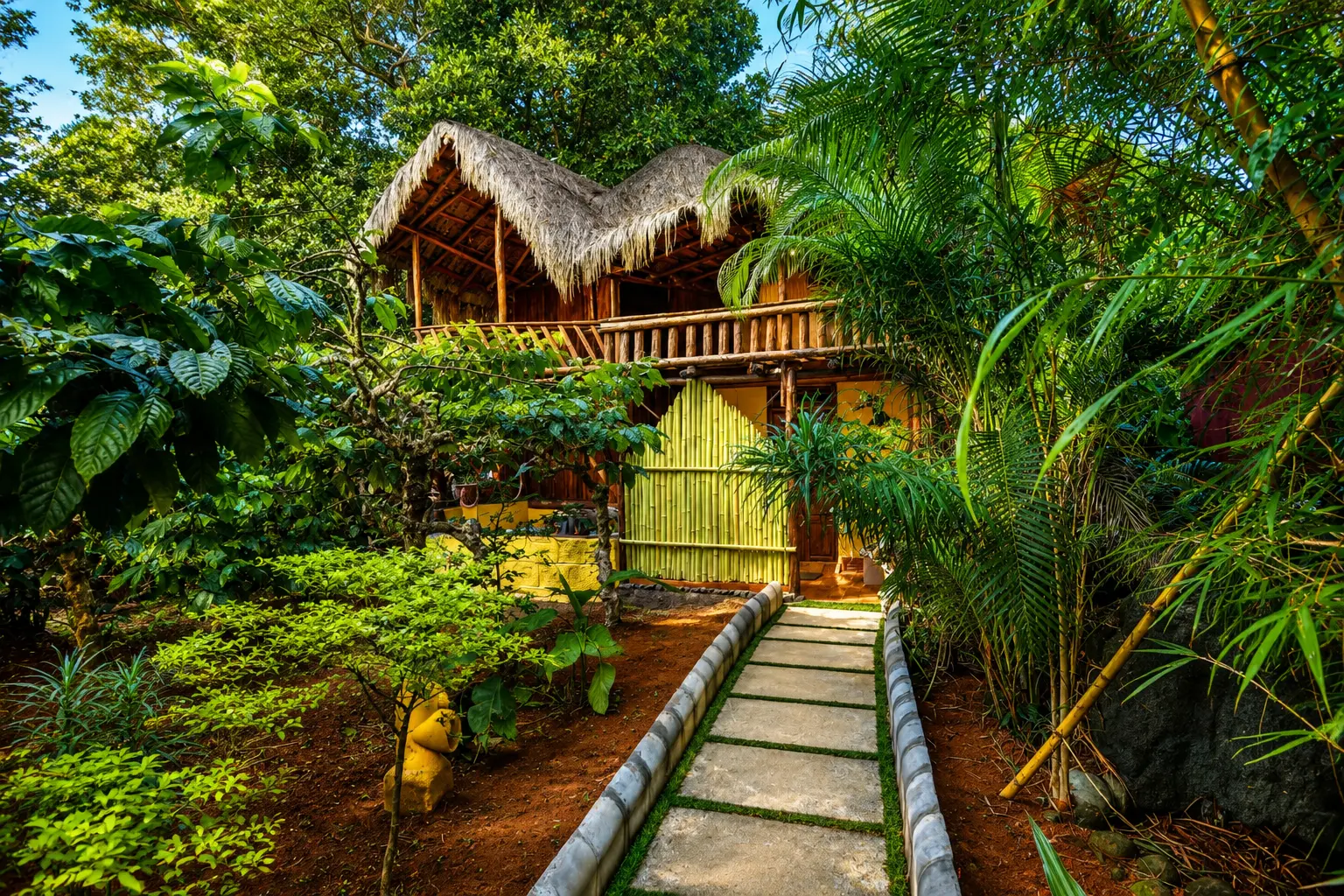 Lime-green wooden cottage interior with attic staircase and extra bed