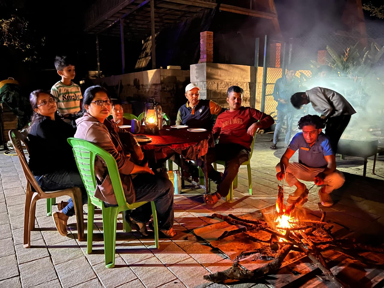 Guests gathered around a warm campfire at night