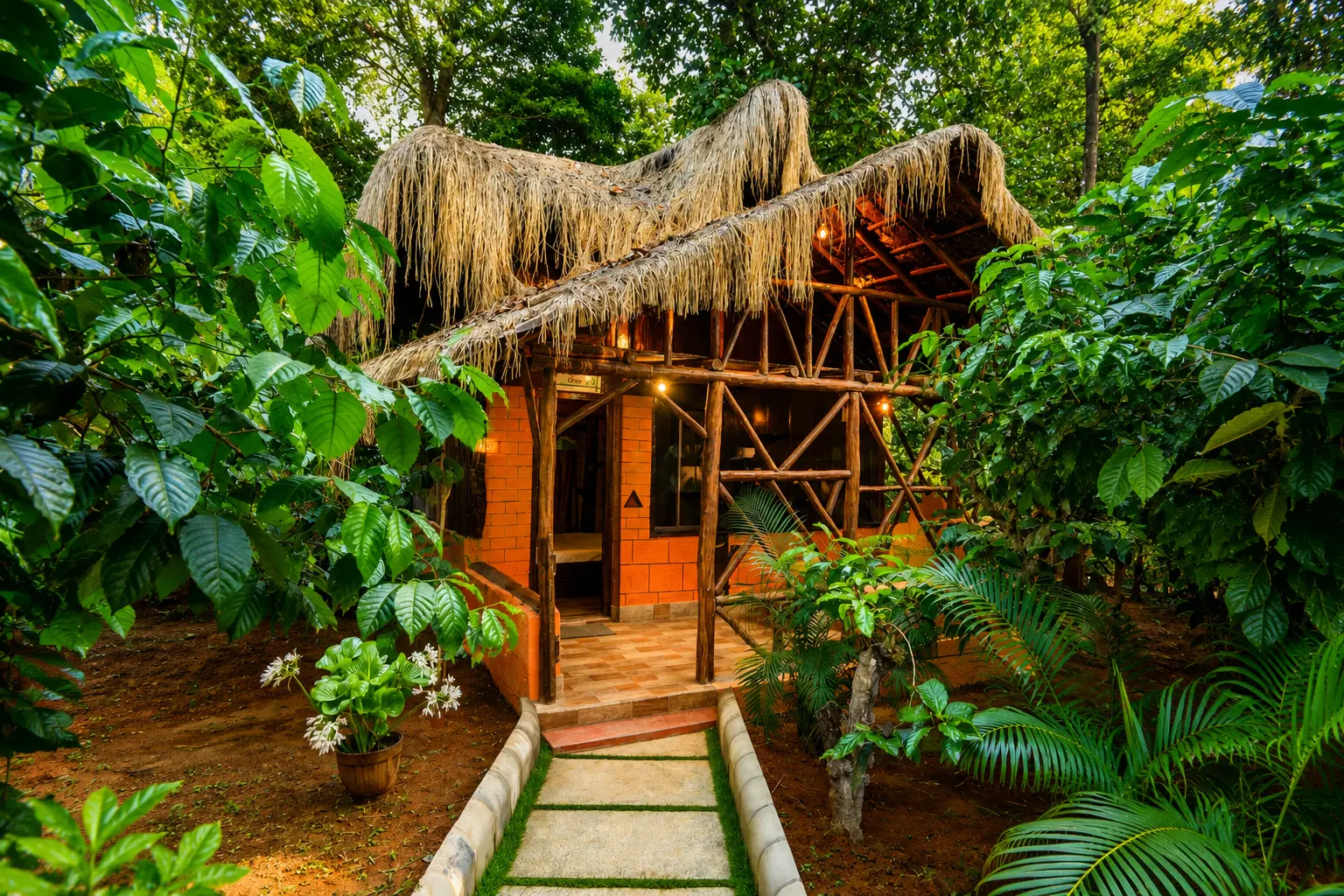 Thatched-roof rustic cottage exterior surrounded by coffee plantation greenery
