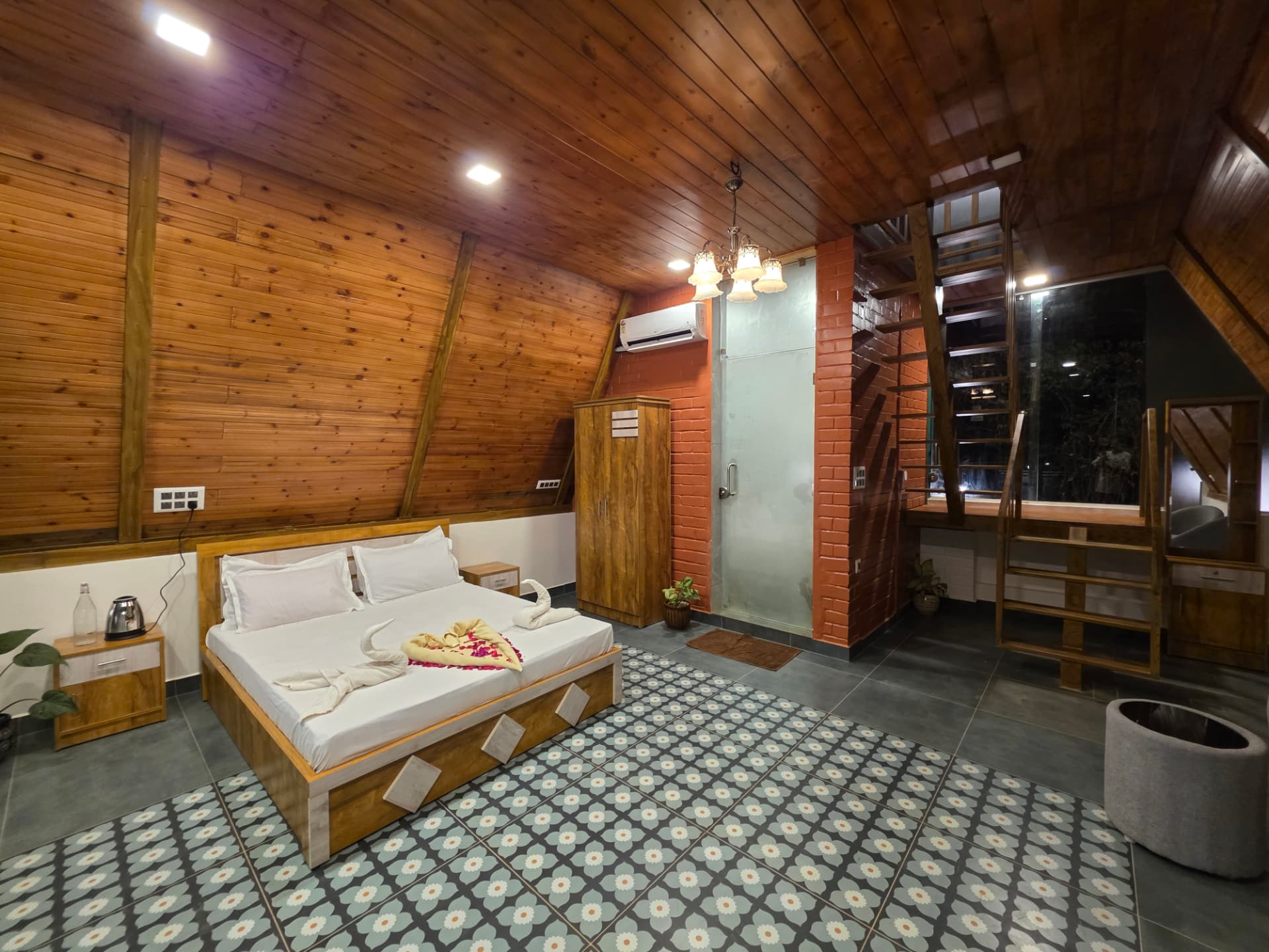 A-Frame cottage main bedroom with chandelier, wardrobe and patterned tile floor