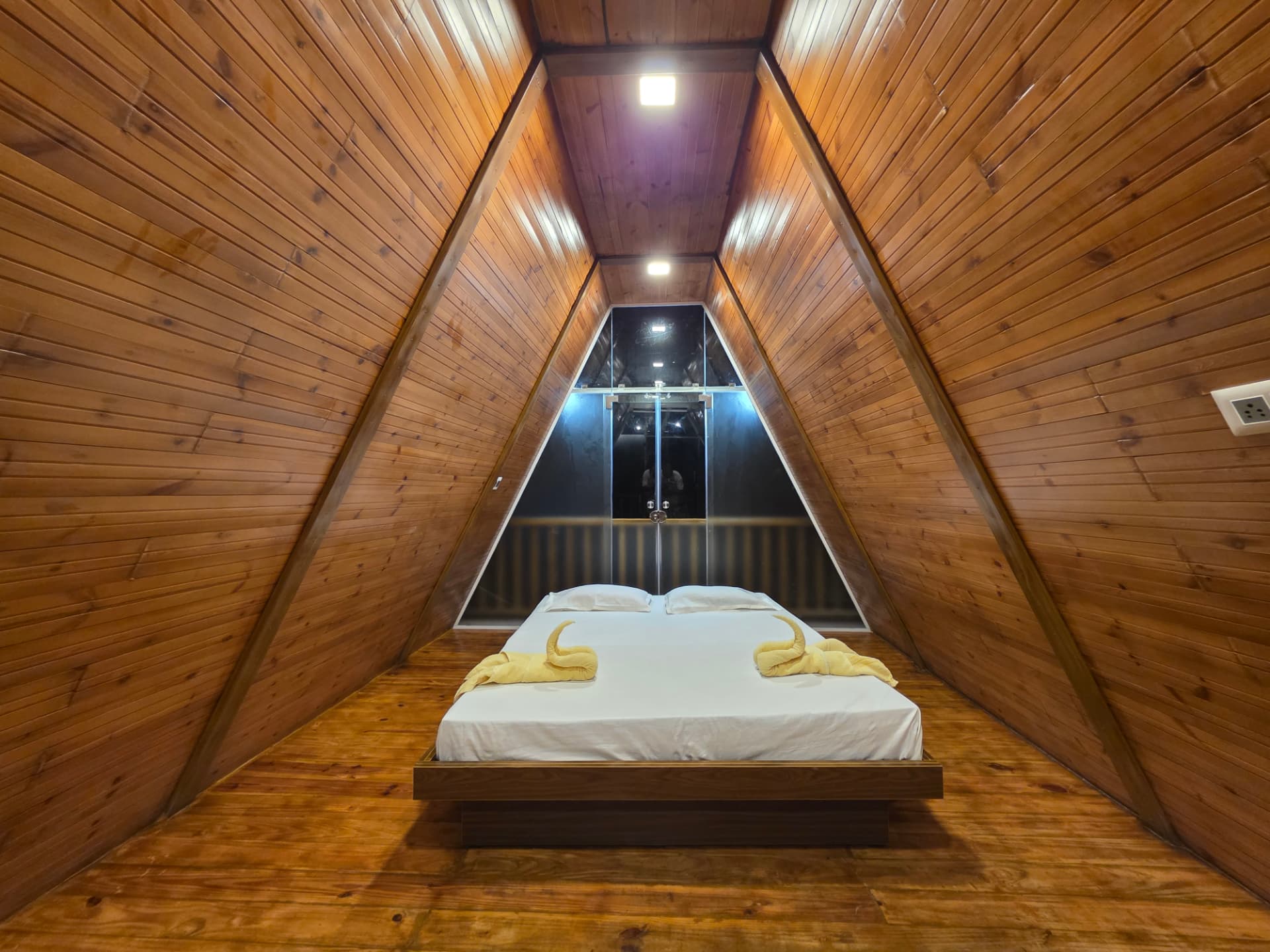 Symmetrical A-Frame attic bedroom with warm wooden panelling