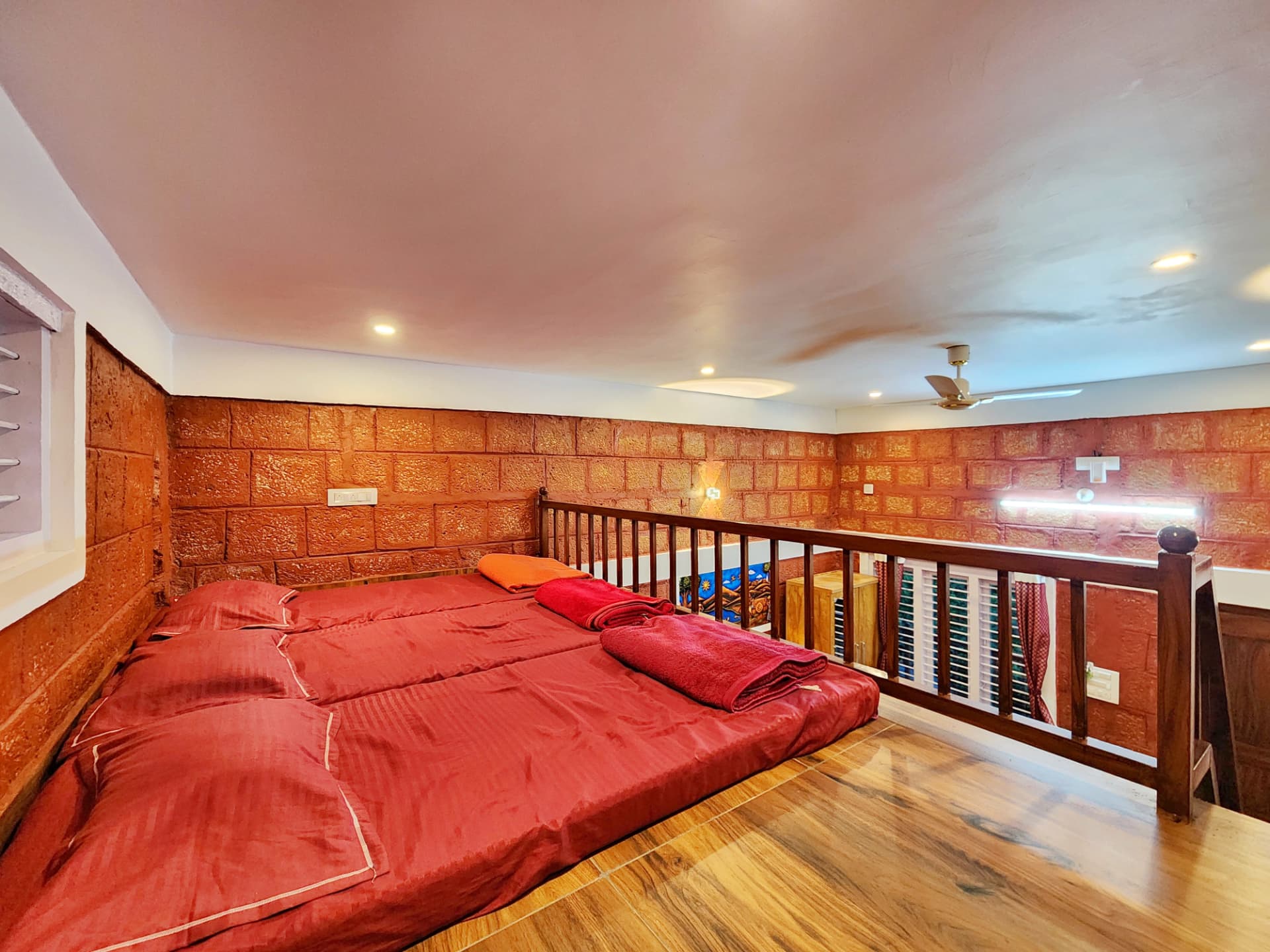 Loft bedding area with laterite stone walls inside a Stone Age Room